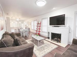 a living room with a couch and a fireplace with a tv at THE FARMHOUSE - FAMILY FRIENDLY DOWNTOWN COTTAGE in San Antonio