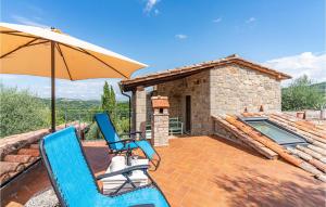 a patio with two chairs and an umbrella and a pool at La Selvarella in Seggiano