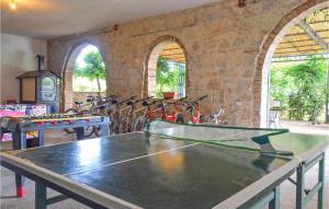 uma mesa de pingue-pongue numa sala com duas mesas em Giglio em Torrita di Siena