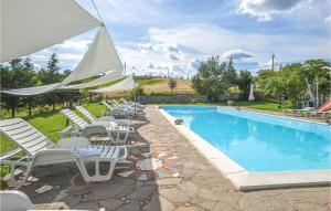 uma piscina com espreguiçadeiras e um grande guarda-sol em Giglio em Torrita di Siena