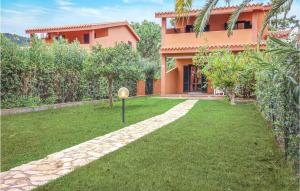 a house with a lawn in front of it at Gorgeous Apartment In Costa Rei -Ca- With Wifi in Costa Rei