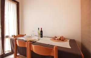 a dining table with two chairs and a table with wine bottles at Gorgeous Apartment In Costa Rei -Ca- With Wifi in Costa Rei