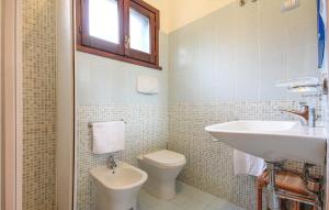 a white bathroom with a sink and a toilet at Gorgeous Apartment In Costa Rei -Ca- With Wifi in Costa Rei +5 photos