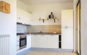 a white kitchen with white cabinets and appliances at App, Centootto in Badolato