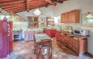 uma cozinha com armários vermelhos e uma mesa com cadeiras em Poggione em Gaiole in Chianti