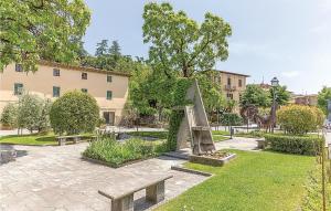 un parc avec des bancs et des arbres et un bâtiment dans l'établissement Poggione, à Gaiole in Chianti