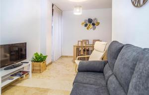 a living room with a gray couch and a television at Beautiful Apartment In Crdoba With Kitchenette in Córdoba