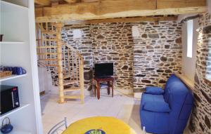 a living room with a stone wall and a blue couch at Amazing Home In Minihy Treguier With 1 Bedrooms And Wifi in Minihy-Tréguier