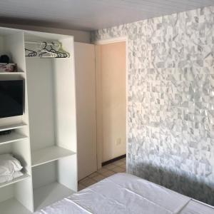um quarto com uma parede em pedra e uma cama em Ancorar Flat - dois quartos em Porto de Galinhas