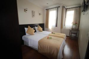 a bedroom with a bed with white sheets and flowers on it at Sultans Hotel in Istanbul