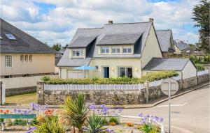 een wit huis met een stenen hek en bloemen bij Gorgeous Home In Quinville With Kitchen in Quinéville