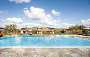 uma grande piscina com cadeiras e guarda-sóis em Le Rose em Ulignano