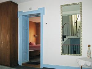 un couloir avec un miroir et une chambre avec un lit dans l'établissement Hotel-Gasthof Seehof Laax, à Laax