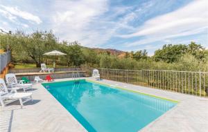 a swimming pool with two chairs and a fence at Beautiful Home In Casalguidi Pt in Cantagrillo