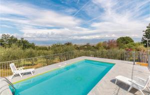 a swimming pool with two chairs next to a fence at Beautiful Home In Casalguidi Pt in Cantagrillo