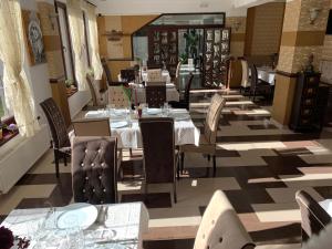 a dining room with tables and chairs in a restaurant at Hotel boutique Garden Resort by Brancoveanu in Moieciu de Jos