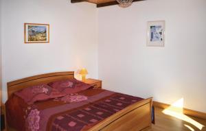 a bedroom with a bed with a purple comforter at Amazing Home In Meslan With Kitchen in Meslan
