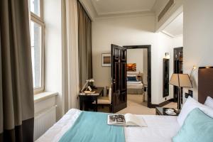 a bedroom with a bed and a desk and a mirror at Astoria Hotel in Lviv