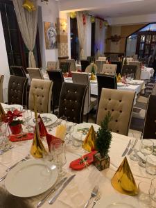 a dining room with white tables and chairs at Hotel boutique Garden Resort by Brancoveanu in Moieciu de Jos