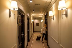 a woman walking down a hallway with a dog at Astoria Hotel in Lviv