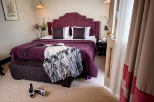 a bedroom with a large bed with a purple bedspread at Astoria Hotel in Lviv