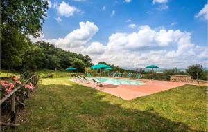 una piscina con sombrillas azules en un campo en La Capannina, en Radicondoli