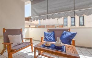 eine Terrasse mit 2 Stühlen, einem Tisch und einer Vase in der Unterkunft 2 Bedroom Amazing Apartment In Trappeto in Trappeto