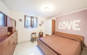 a bedroom with a bed with a love sign on the wall at Casa Mare in Magomadas +8 photos