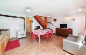 eine Küche und ein Esszimmer mit einem Tisch und roten Stühlen in der Unterkunft Baita in Lamon