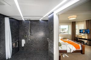 a bathroom with a shower and a bed in a room at Astoria Hotel in Lviv