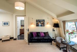 a living room with a black couch and purple pillows at Astoria Hotel in Lviv