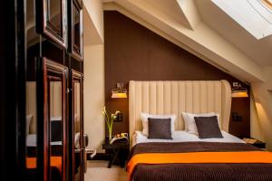 a bedroom with a large bed with an orange blanket at Astoria Hotel in Lviv