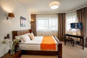 a hotel room with a bed and a desk in it at Astoria Hotel in Lviv