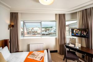 a hotel room with a bed and a desk and a window at Astoria Hotel in Lviv