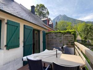a table and chairs on a balcony with a house at Le 103. Chalet 3 chambres. Terrasse. Parking. wifi. in Cauterets