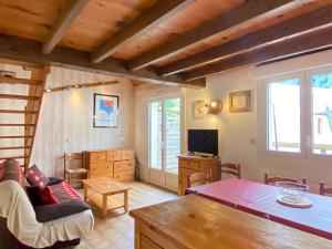 a living room with a couch and a tv at Le 103. Chalet 3 chambres. Terrasse. Parking. wifi. in Cauterets
