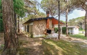 a brick house with an orange roof in the woods at Casa Laura 1 in Lignano Sabbiadoro