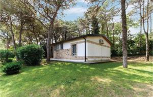 a small white building in a yard with trees at Casa Laura 1 in Lignano Sabbiadoro