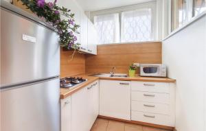 a kitchen with white cabinets and a stainless steel refrigerator at Casa Laura 1 in Lignano Sabbiadoro +10 photos