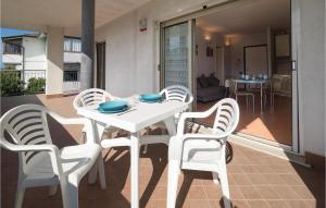 a white dining table and chairs on a patio at Orizzonte 2 in Lido di Dante