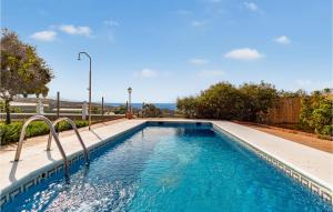a swimming pool with blue water in a yard at Nice Home In Velez - Malaga With Wifi in Vélez-Málaga