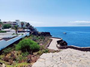 widok na ocean z łodzią w wodzie w obiekcie MARAVILLA Suite 140 m2 - 3 Bedrooms, Heated Pool w mieście Costa Del Silencio