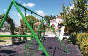 a green swing set in front of a house at Stunning Home In Olvera in Olvera