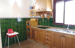a green tiled kitchen with a sink and a red stool at Stunning Home In Olvera in Olvera