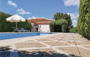 - une piscine avec un parasol et une maison dans l'établissement Pet Friendly Home In Olvera With Kitchen, à Olvera