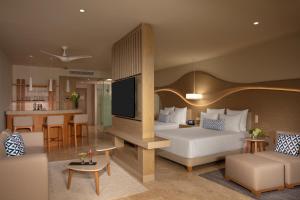 a hotel room with a bed and a living room at Breathless Cancun Soul Resort & Spa - Adults Only - All Inclusive in Cancún +68 photos