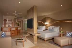 a hotel room with a bed and a living room at Breathless Cancun Soul Resort & Spa - Adults Only - All Inclusive in Cancún