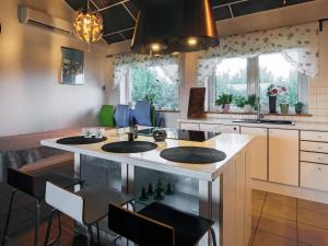 a kitchen with a island with a sink and chairs at 11 person holiday home in V ggerl se in Marielyst