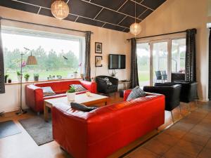 a living room with red furniture and a large window at 11 person holiday home in V ggerl se in Marielyst