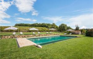 a swimming pool in a yard with chairs and umbrellas at Casa Chiara in Gaiole in Chianti